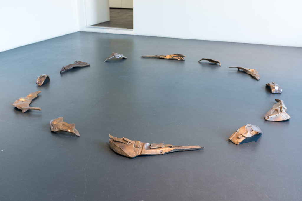 Lattialla valetusta pronssista tehty ympyrämuotoinen taideteos.